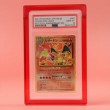 Ruby Red Card Guard on a ruby background, holding a PSA graded Charizard slab